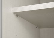 Innenansicht eines Schwebetürenschranks mit einem Regalbrett und silbernen Halterungen, seitliche Perspektive.