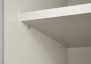 Innenansicht eines Schwebetürenschranks mit einem Regalbrett und silbernen Halterungen, seitliche Perspektive.