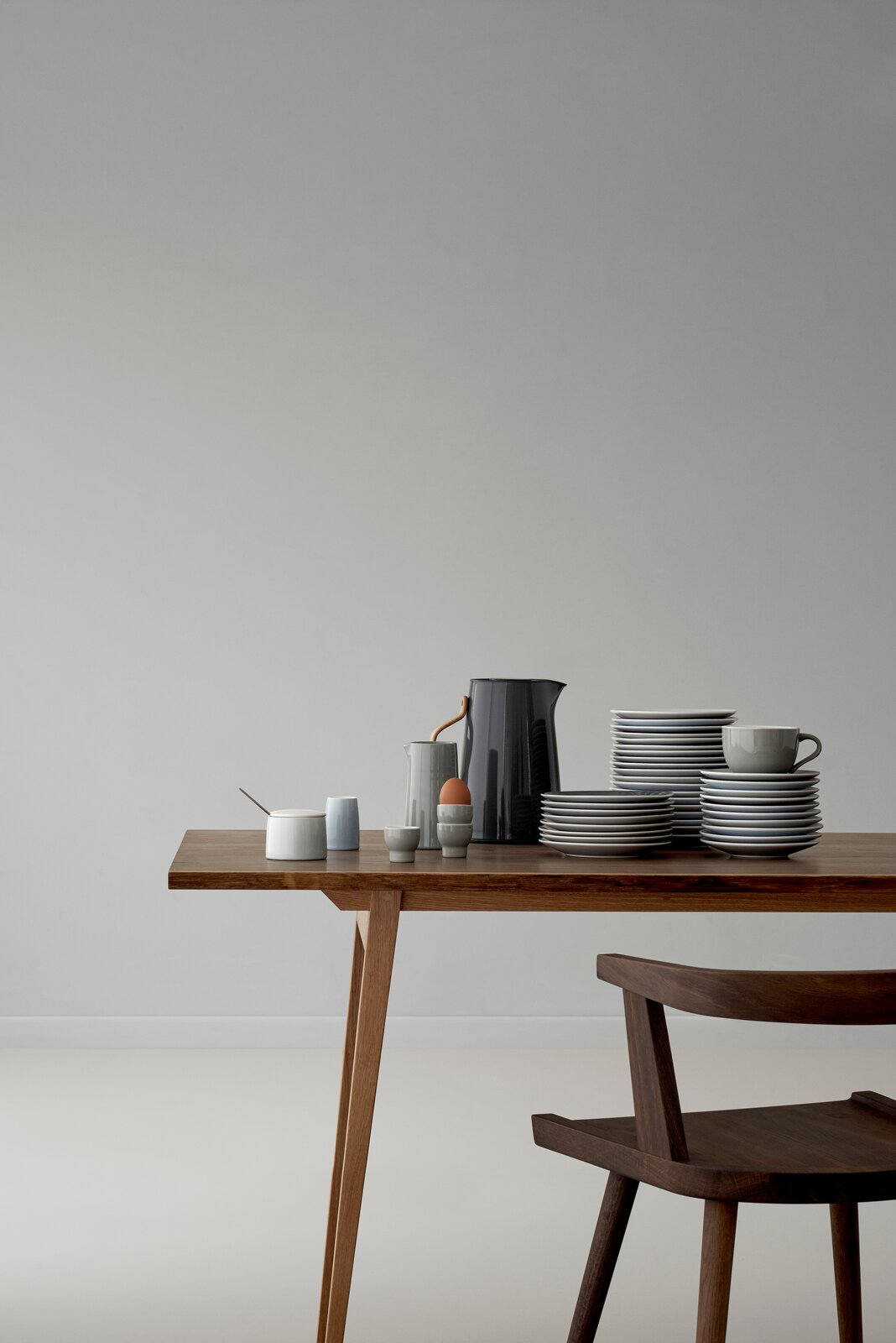 Stelton Emma Wasserkocher in elegantem Design auf einem Tisch, umgeben von Geschirr, seitliche Perspektive.