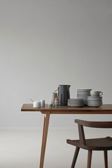 Stelton Emma Wasserkocher in elegantem Design auf einem Tisch, umgeben von Geschirr, seitliche Perspektive.