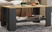 Moderner Couchtisch mit heller Holzplatte und schwarzem Gestell, mit Ablageboden für Zeitschriften, im Wohnzimmer vor einem Sofa – Frontansicht in leichter Schrägperspektive