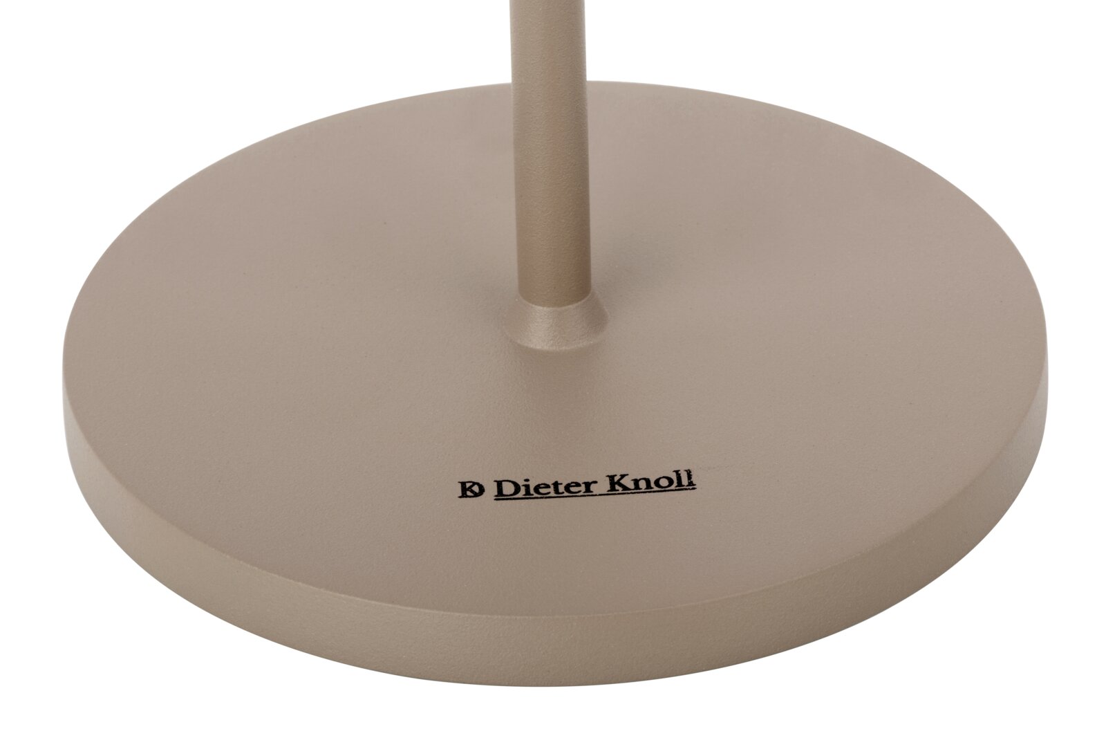 Close-up van de voet van een accu-tafellamp van Dieter Knoll, beige, met merklogo, gezien van bovenaf.