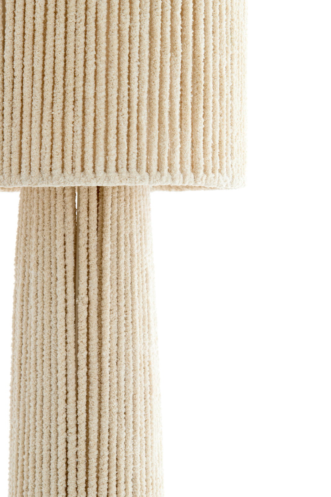 Nahaufnahme einer Stehleuchte mit cremefarbenem, geripptem Stoffbezug.