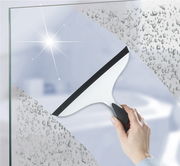 Hand hält Badezimmerwischer 2K Loano, der Wasser von einer Glasoberfläche entfernt. Perspektive von vorne.