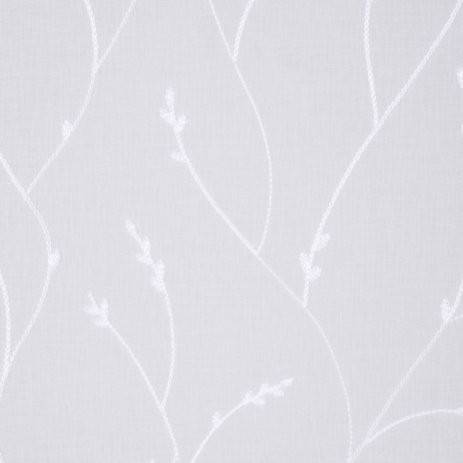 Nahaufnahme eines weißen Fertigvorhangs mit zartem, floralem Muster.