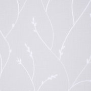 Nahaufnahme eines weißen Fertigvorhangs mit zartem, floralem Muster.