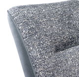 Nahaufnahme eines Kufenstuhls mit grauem, strukturiertem Stoffbezug, seitliche Perspektive