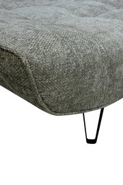 Nahaufnahme einer grauen Polstergarnitur mit texturierter Oberfläche und schwarzen Metallbeinen, seitliche Perspektive