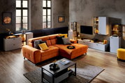 Moderne Wohnzimmermöbel in einem stilvollen Raum mit einem großen orangefarbenen Sofa, umgeben von weißen und schwarzen Schränken und einem Couchtisch. Perspektive: Frontalansicht des Wohnzimmers.