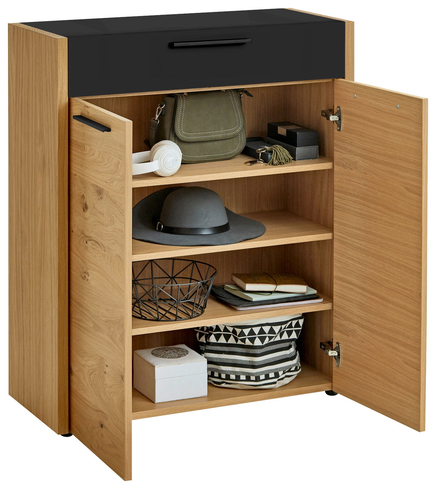 Kommode aus der Serie LEVIO von VOSS mit geöffneter Tür, zeigt Innenfächer mit verschiedenen Gegenständen, aus einer frontalen Perspektive.