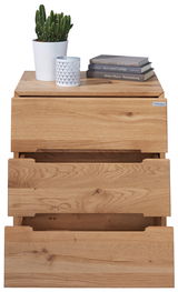 Nachtkonsole aus Holz mit drei Schubladen, darauf ein Kaktus in einem weißen Topf, eine dekorative Kerze und drei Bücher. Frontalansicht.