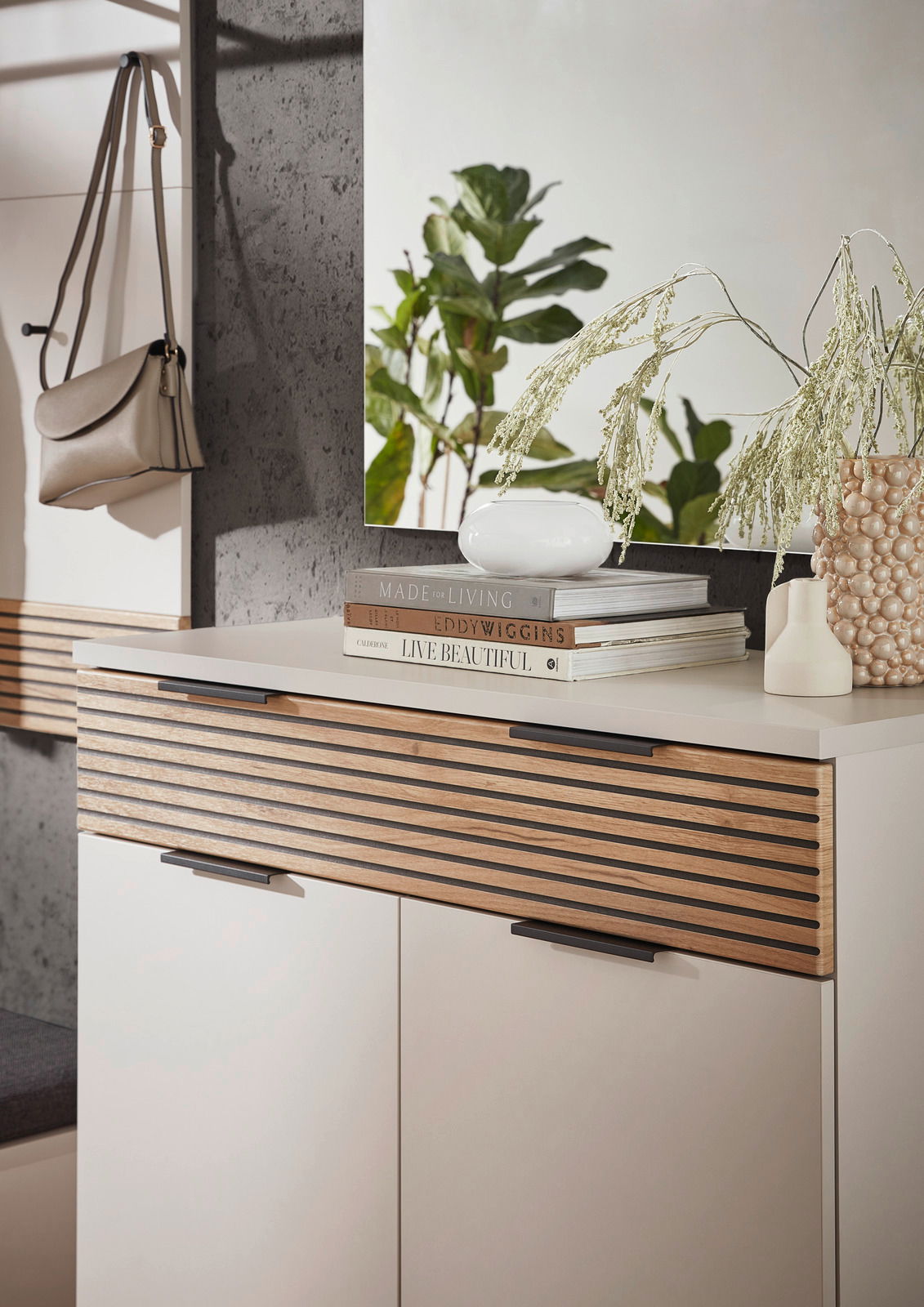 Moderner Schuhschrank mit Holzlamellen-Design, dekoriert mit Büchern und Vasen, seitliche Perspektive