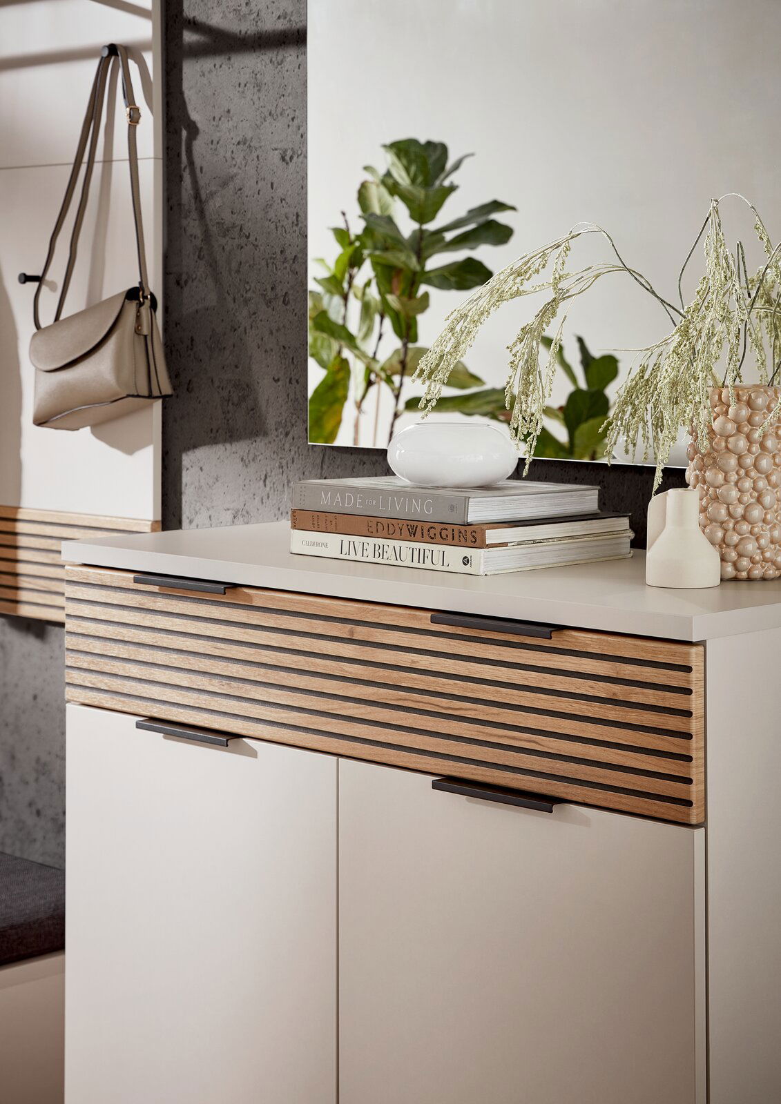 Moderner Schuhschrank mit Holzlamellen-Design, dekoriert mit Büchern und Vasen, seitliche Perspektive