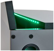 Nahaufnahme eines Gamingtisches mit grüner LED-Beleuchtung und Lautsprecheröffnung, seitliche Perspektive