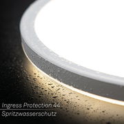 Nahaufnahme einer LED-Deckenleuchte mit Bewegungssensor, die spritzwassergeschützt ist und Wassertropfen auf der Oberfläche zeigt.