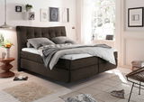 Gemütliches Boxspringbett in modernem Schlafzimmer, seitliche Perspektive