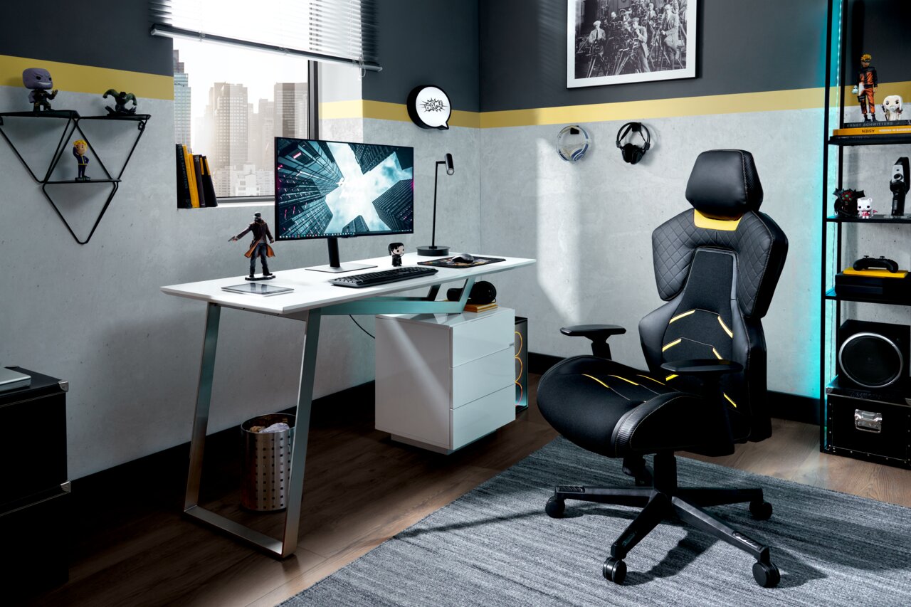 Moderner Schreibtisch mit Monitor und Gaming-Stuhl in einem stilvollen Arbeitszimmer, seitliche Perspektive.