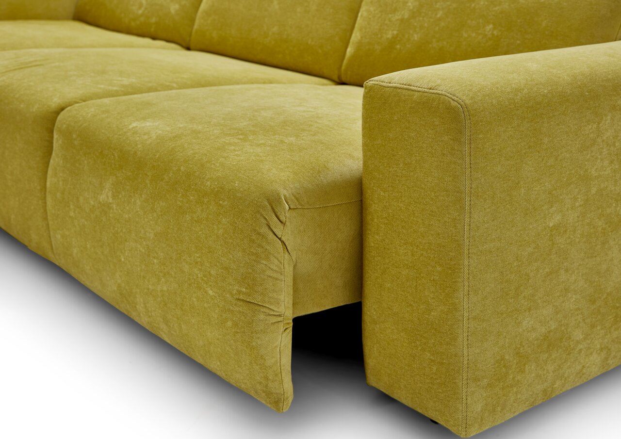Close-up van een moderne ligstoelcombinatie in een levendige olijfgroene kleur, met een zachte stoffen bekleding en strakke lijnen, gezien vanaf de zijkant.