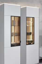 Moderne Vitrine mit Glasfronten, beleuchtetem Innenraum und stilvoller Präsentation von Geschirr, seitliche Perspektive