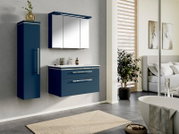 Modernes, wandhängendes Badmöbel-Set in Dunkelblau mit Waschtischunterschrank (zwei Schubladen), weißem Waschtisch, Spiegelschrank mit drei Türen und LED-Leuchte sowie passendem Hochschrank; Frontansicht in leichter Perspektive von rechts.