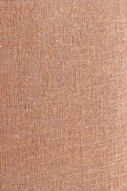 Nahaufnahme eines strukturierten, gewebten Lampenschirms in warmem Braunton.