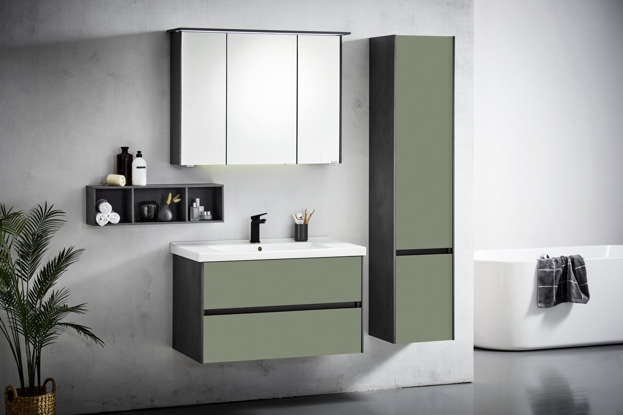 Moderne Badkombination in grauer und grüner Farbe, bestehend aus einem Waschbeckenunterschrank, einem hohen Schrank und einem Spiegelschrank, seitliche Perspektive