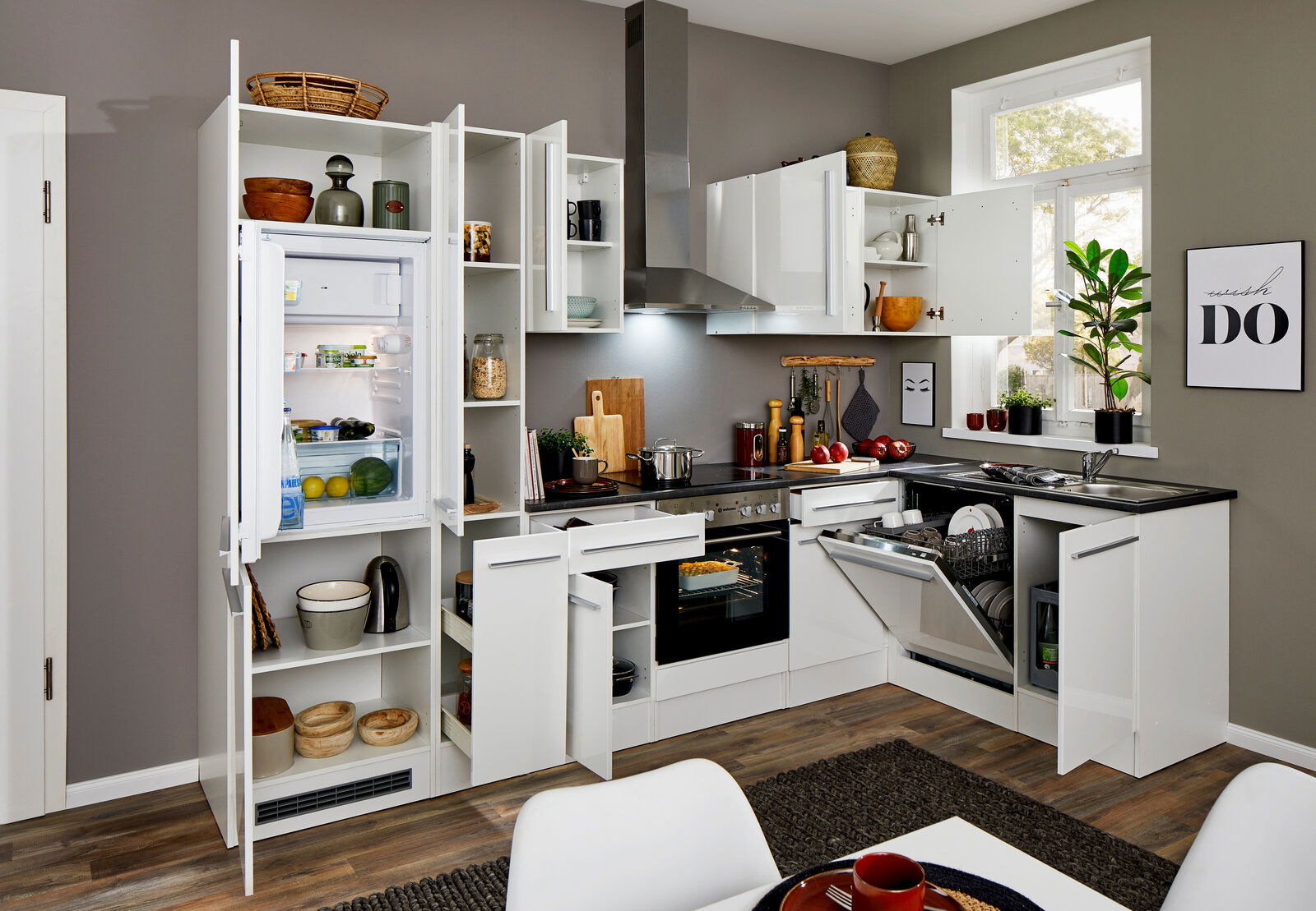 Moderne weiße Eckküche mit geöffneten Schränken und Geräten, Blick von vorne.