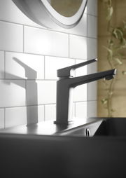 Moderne Waschtischarmatur in seitlicher Perspektive, montiert auf einem Waschbecken vor einer gefliesten Wand.