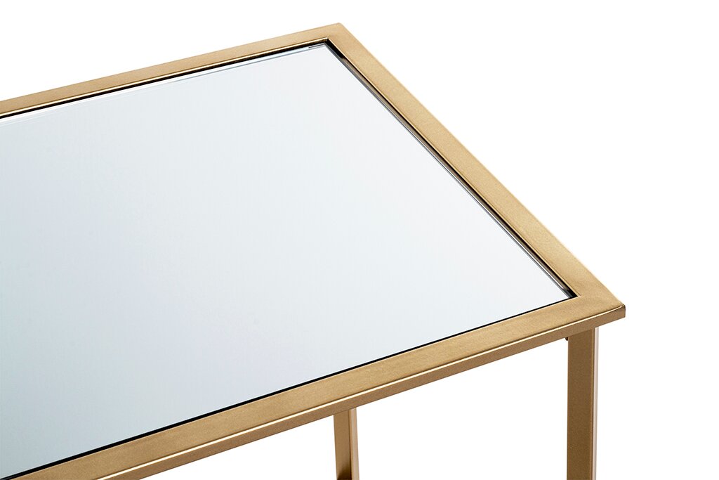 Nahaufnahme eines rechteckigen Beistelltischs mit Spiegelglasplatte und goldfarbenem Metallrahmen, leicht von oben in schräger Perspektive fotografiert