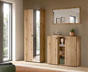 Modernes Flurmöbel-Set aus hellem Holz mit vertikaler Lamellenfront: hoher Garderobenschrank mit Spiegel und daneben Sideboard mit offenen Regalfächern, darüber ein Wandspiegel; Ansicht frontal mit leichter Perspektive von links.