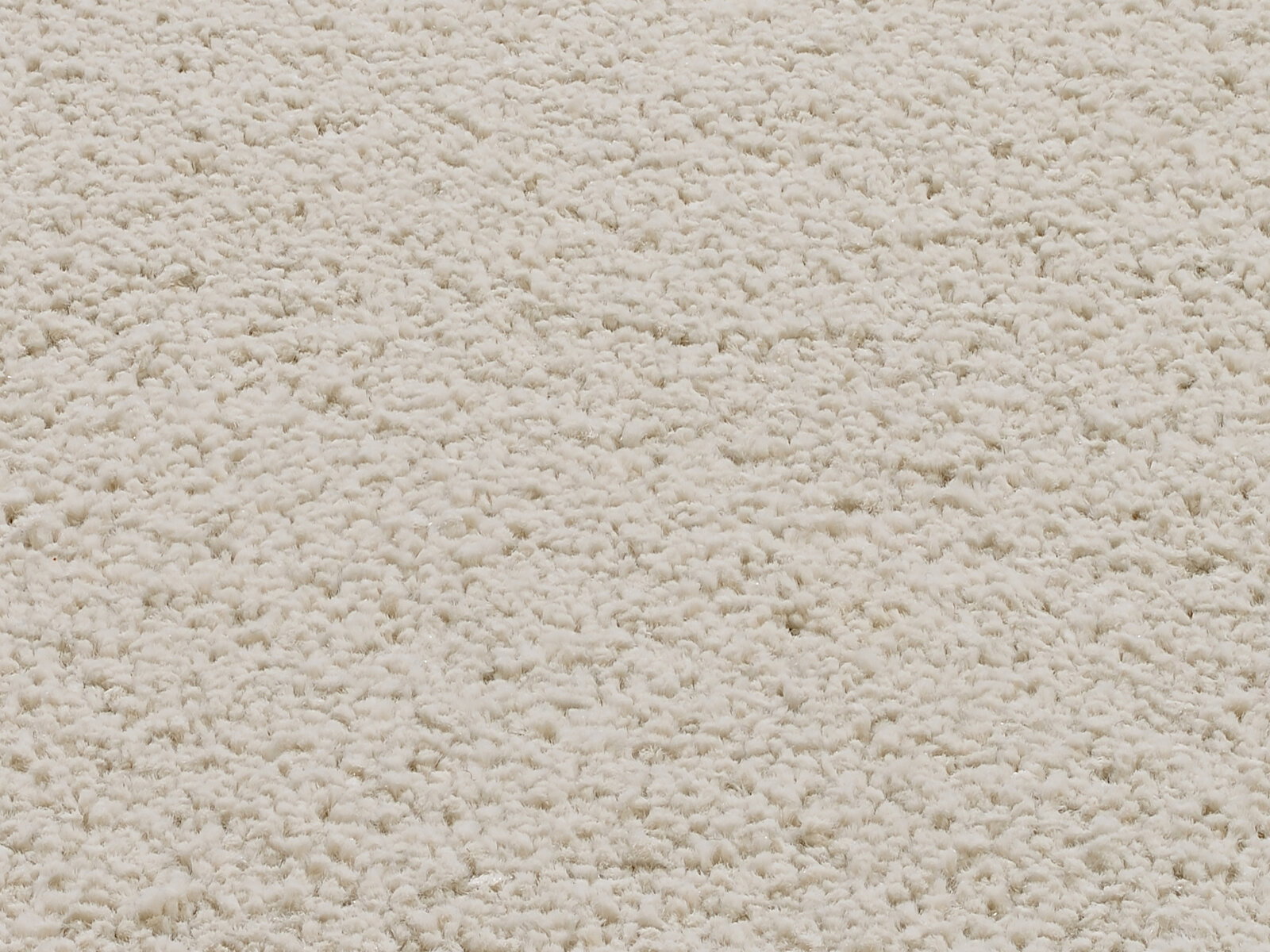 Nahaufnahme eines cremeweißen Uni-Teppichs mit weicher, flauschiger Textur.