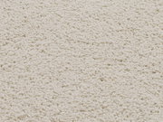 Nahaufnahme eines cremeweißen Uni-Teppichs mit weicher, flauschiger Textur.