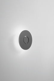 LED-Außenwandleuchte in runder Form, seitliche Perspektive, an einer weißen Wand montiert