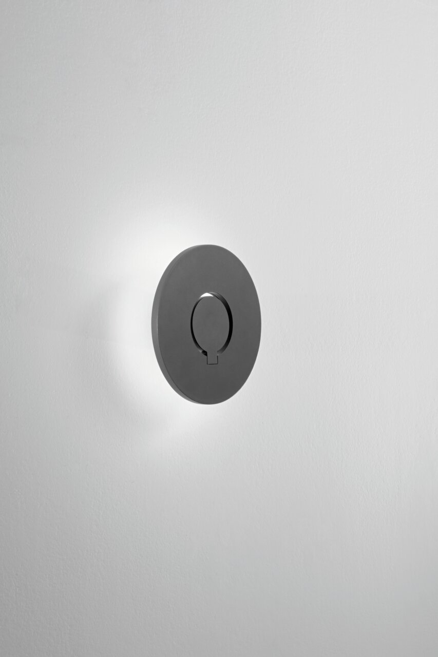 LED-Außenwandleuchte in runder Form, seitliche Perspektive, an einer weißen Wand montiert