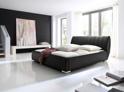 Modernes Polsterbett in schwarzem Lederdesign, seitliche Perspektive, in einem hellen Raum mit großen Fenstern und stilvoller Dekoration.