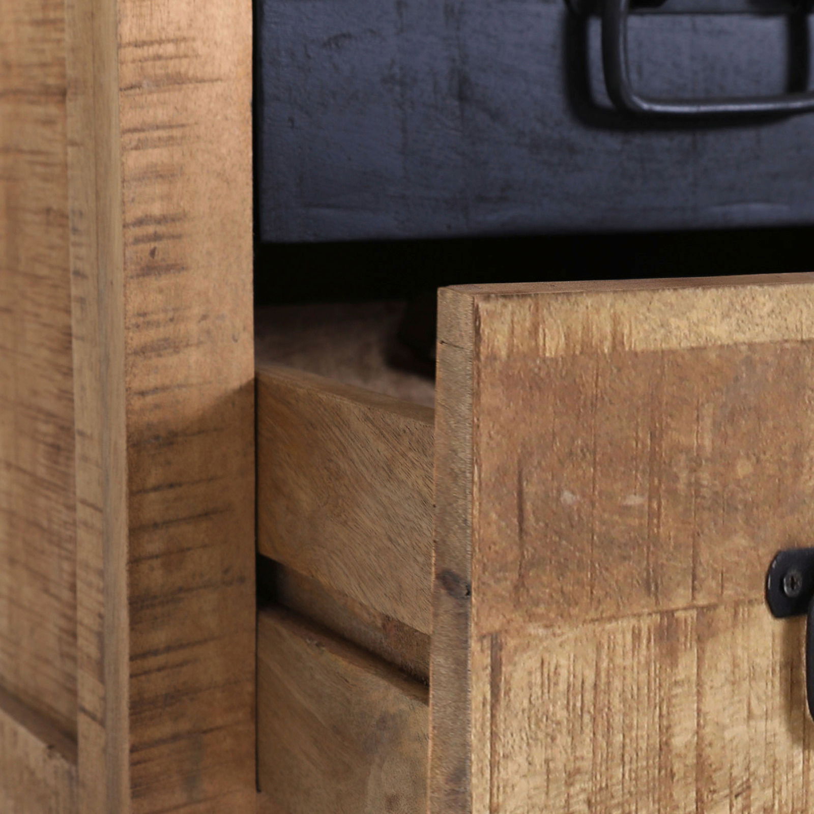 Nahaufnahme einer rustikalen Nachtkommode aus Holz mit geöffneter Schublade und schwarzem Griff, seitliche Perspektive