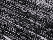 Nahaufnahme eines Designer Teppichs mit diagonalen, strukturierten Linien in Grautönen.