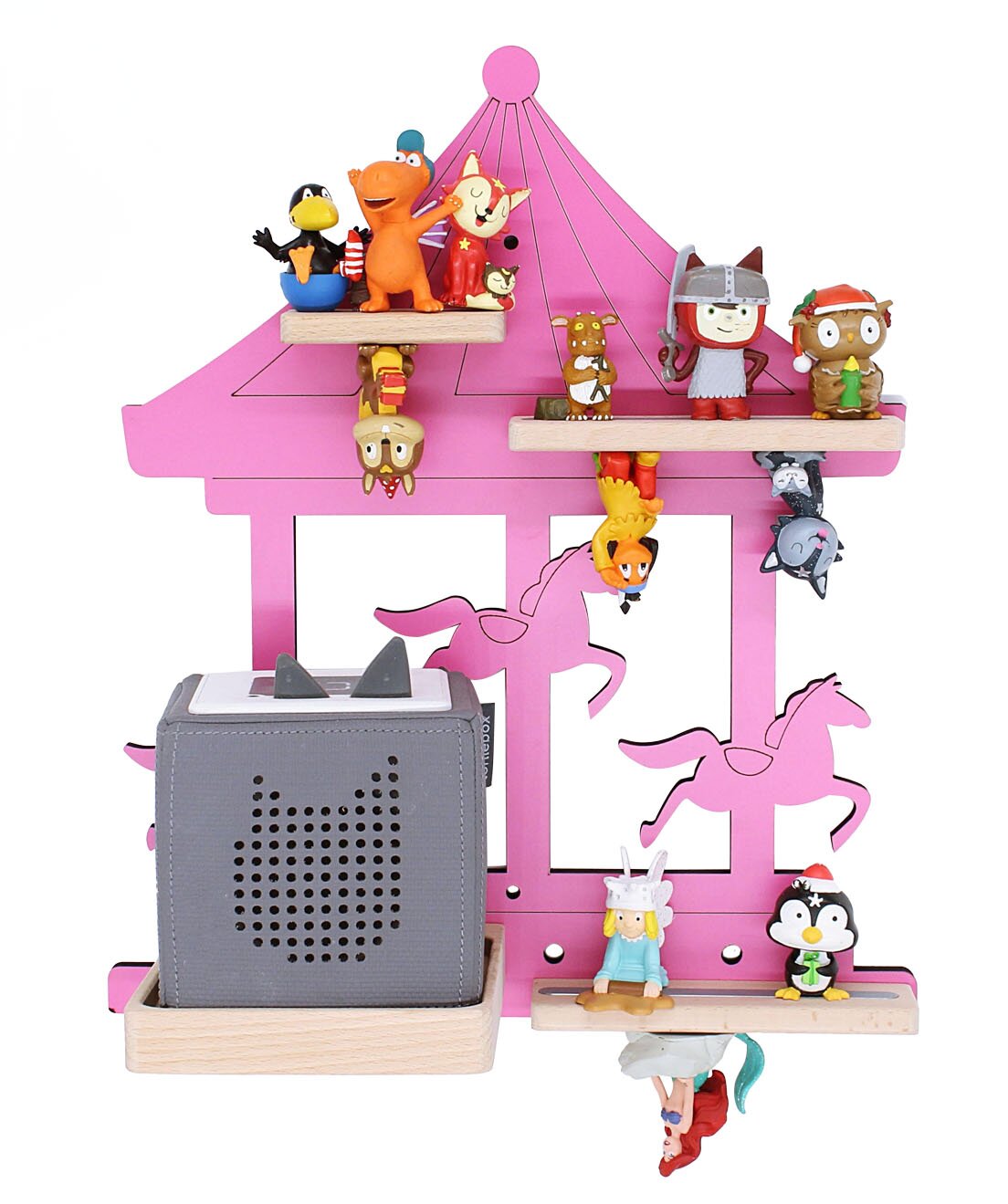 Vorderansicht eines pinken Karussell-Regals mit Pferde-Silhouetten und mehreren kleinen Tier- und Figuren-Miniaturen auf Holzablagen links unten steht ein grauer Würfel-Lautsprecher in einer Holzschale.