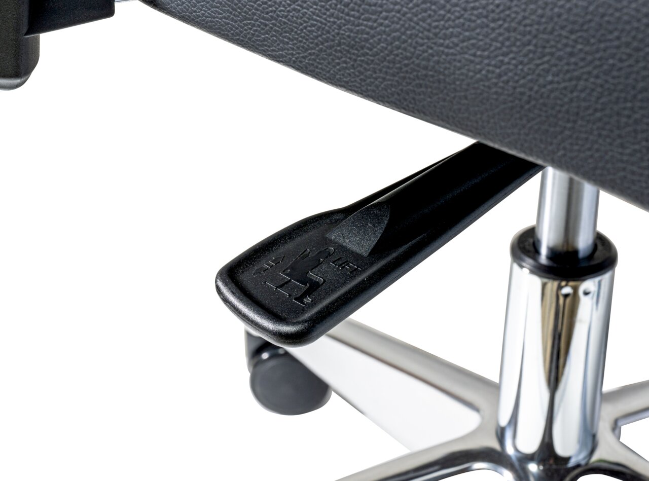 Nahaufnahme eines Hebels zur Höhenverstellung eines Chefsessels, seitliche Perspektive