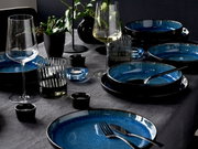 Elegantes Tafelservice 12-tlg in Blau und Schwarz, von schräg oben fotografiert, mit Gläsern und Dekoration auf einem gedeckten Tisch.