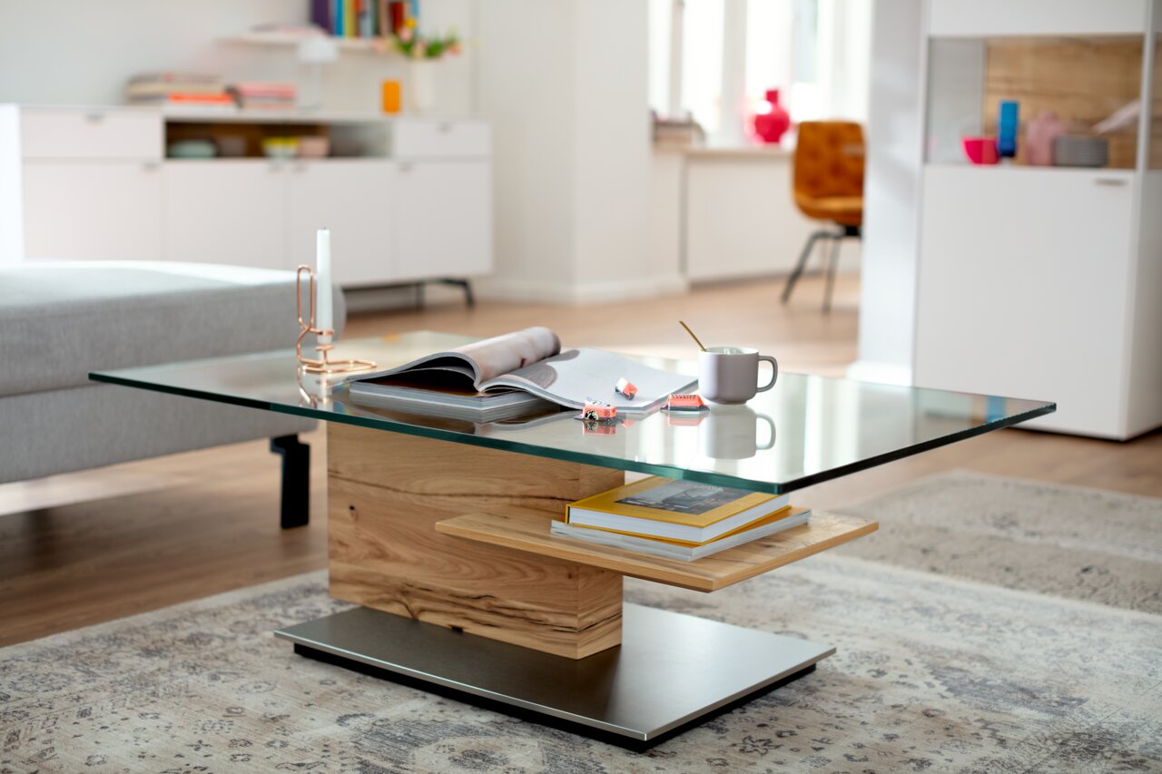 Moderner Couchtisch mit Glasplatte und Holzdetails, seitliche Perspektive