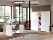 Moderner Büroraum mit weißem Schreibtisch, ergonomischem Stuhl und hohem Aktenschrank, seitliche Perspektive