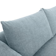 Nahaufnahme eines hellblauen Sofas mit weichen Kissen, Perspektive von oben.