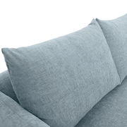 Nahaufnahme eines hellblauen Sofas mit weichen Kissen, Perspektive von oben.