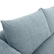 Nahaufnahme eines hellblauen Sofas mit weichen Kissen, Perspektive von oben.