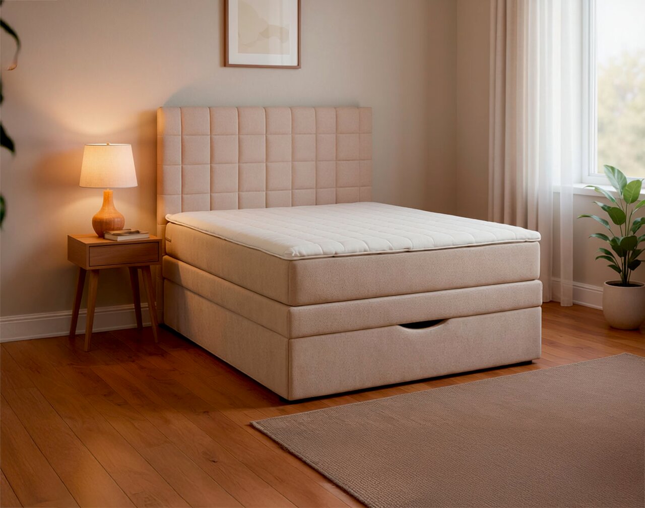 Beiges Boxspringbett mit gepolstertem, quadratisch gestepptem Kopfteil und weißer Matratzenauflage im modernen Schlafzimmer, seitliche Perspektive schräg von vorn