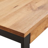 Nahaufnahme eines Couchtischs mit einer Tischplatte aus hellem Holz und einem schwarzen Metallgestell, Perspektive von der Ecke.