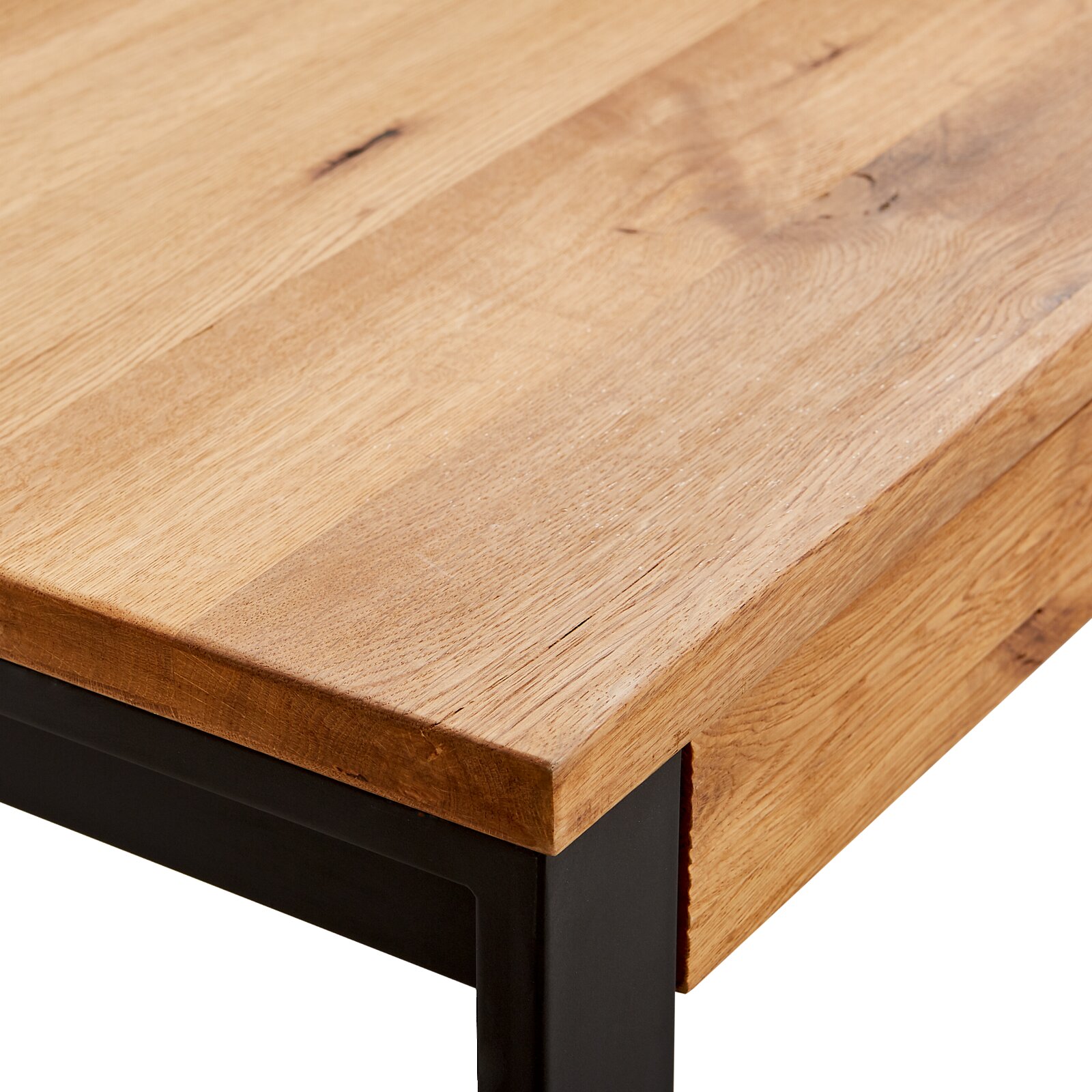 Nahaufnahme eines Couchtischs mit einer Tischplatte aus hellem Holz und einem schwarzen Metallgestell, Perspektive von der Ecke.