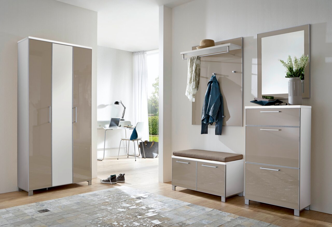 Modernes Garderoben-Set in einem hellen Raum, bestehend aus einem hohen Schrank, einer Sitzbank mit Stauraum, einer Wandgarderobe mit Haken und Ablage sowie einem Spiegel. Perspektive von vorne.