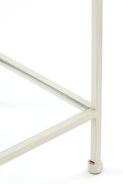 Nahaufnahme eines weißen Metallrahmens eines Standregals mit Glasboden, perspektivisch von unten rechts betrachtet.